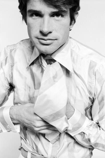 El actor Warren Beatty anudándose la corbata, en 1970
