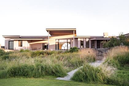 La arquitectura se recorta sobre un mar de pasto llorón (Eragrostis curvula); poco a poco se va conformando una pradera espontánea.